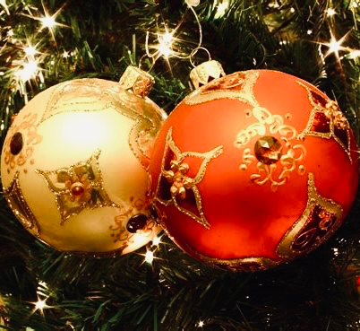 Two large Christmas baubles, hanging on a Christmas tree