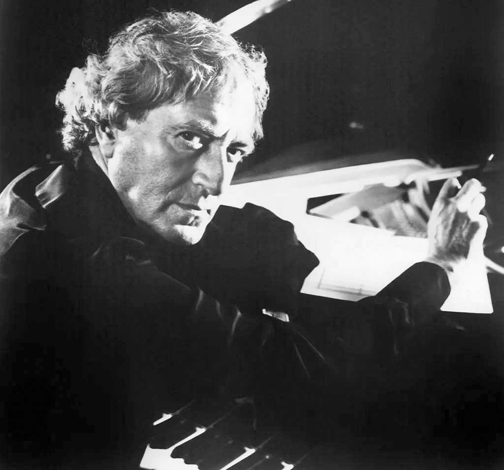 John Barry Side view of John Barry sitting at a piano, with pen poised above a score